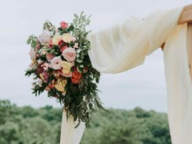 bouquet of assorted-color flowers hanged on brown plank with white textile