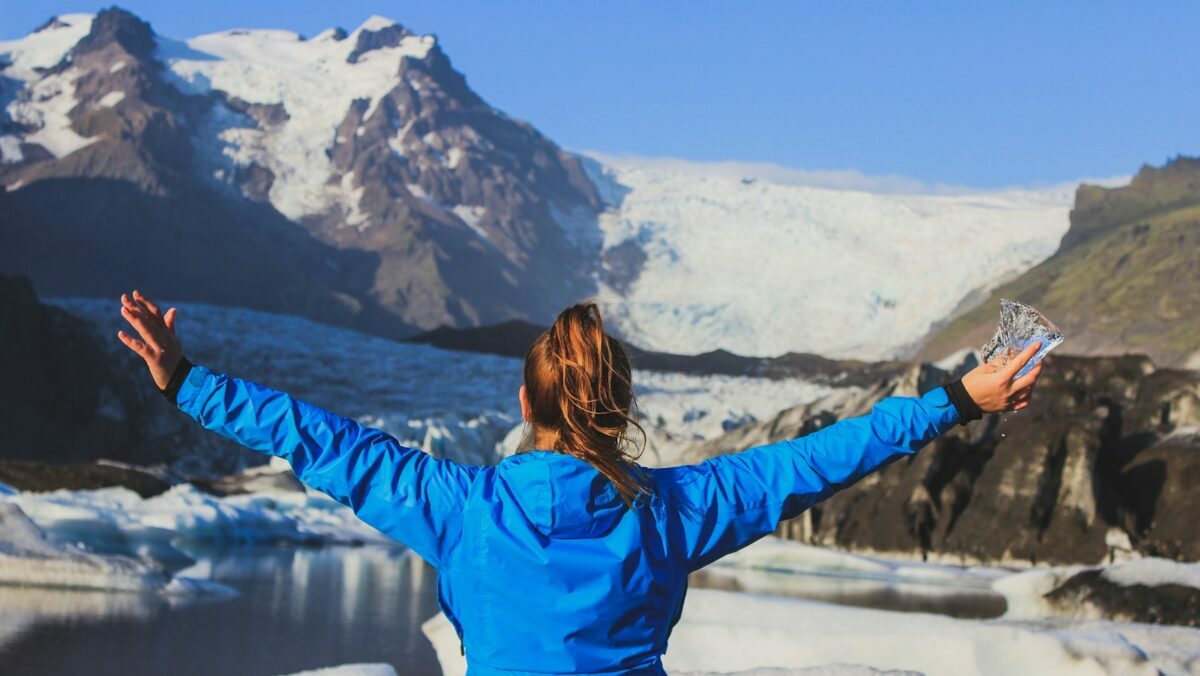 woman in blue jacket standing on snow covered ground during daytime