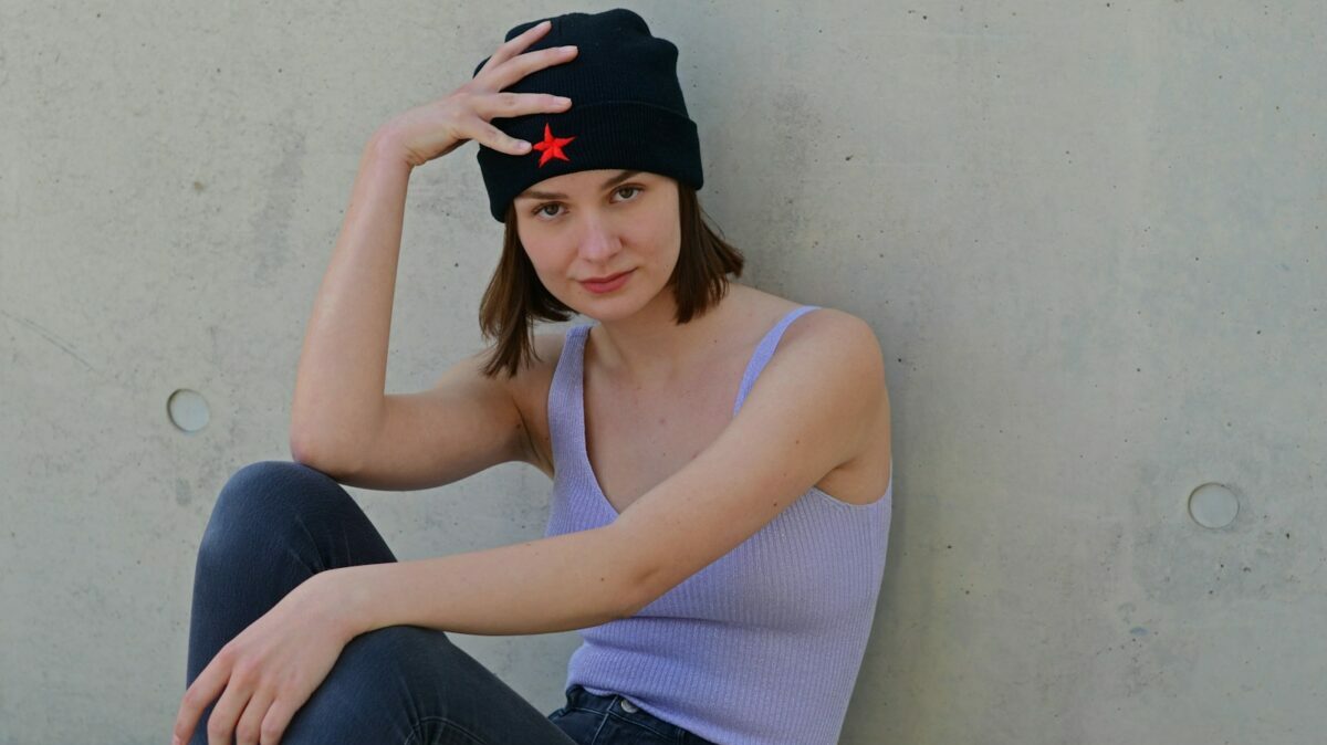 a woman sitting on the ground with her hand on her head