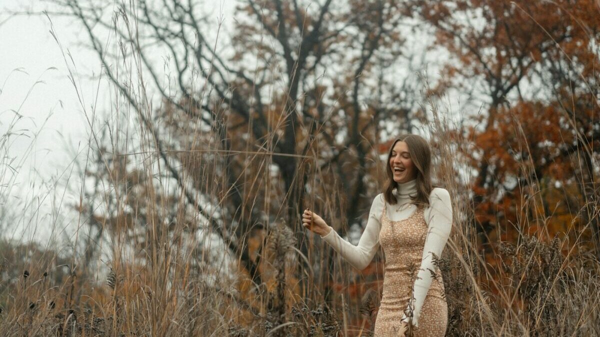 a woman standing in a field holding a kite