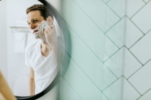 man shaving in front of mirror